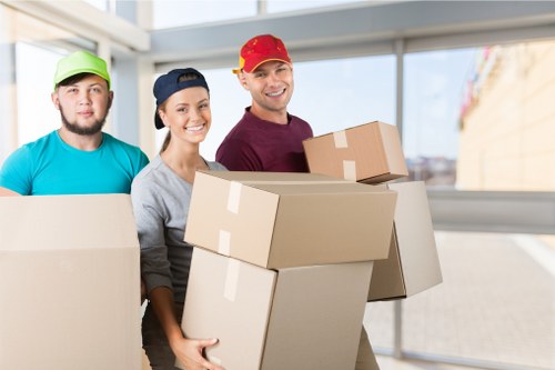 Moving team pricing a Canary Wharf apartment relocation with boxes and furniture
