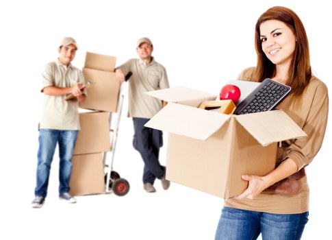 Professional movers carrying boxes through a modern Canary Wharf apartment building